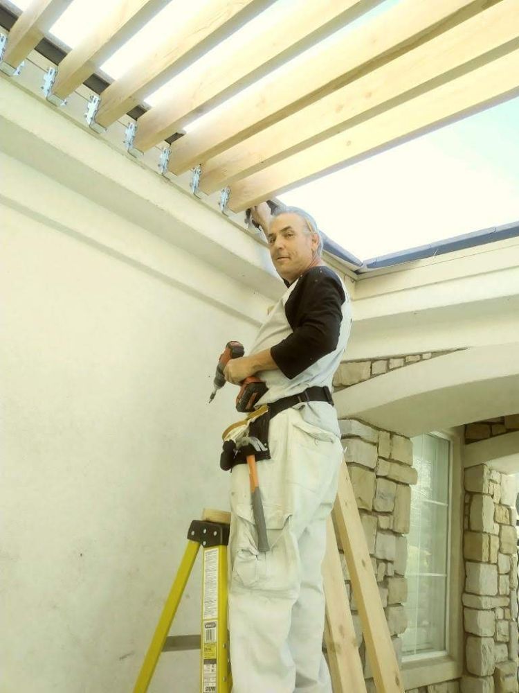 Scott Floyd on ladder building a pergola patio cover